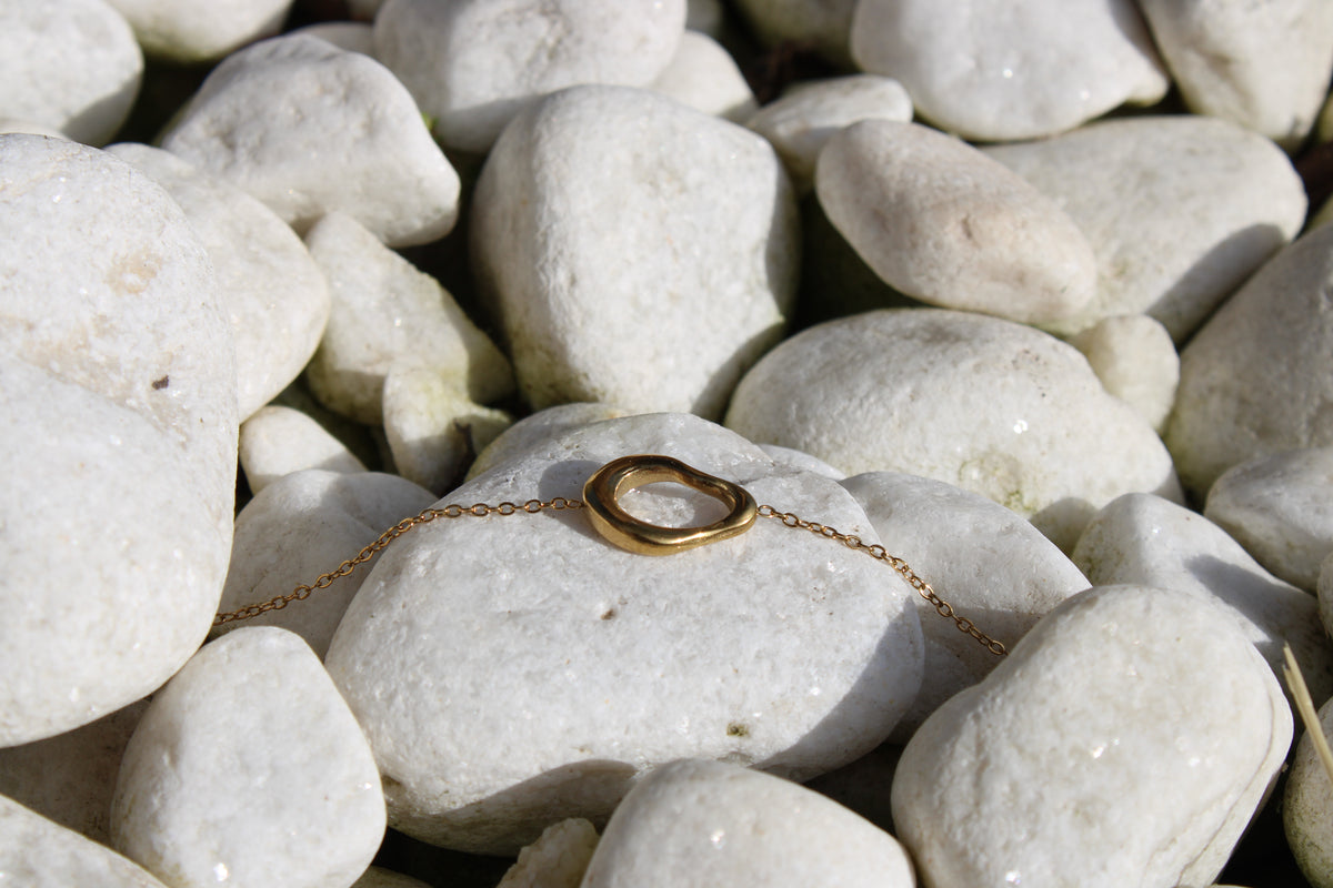 Pulsera sol irregular dorado acero inoxidable, sizygia colección sol sobre piedras blanca